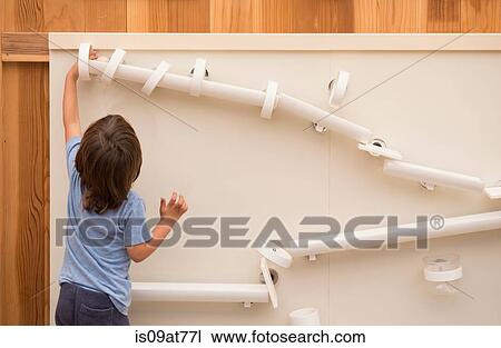 Young boy playing with tumbling puzzle, rear view View Large Photo Image Stock Image - Young boy playing with tumbling puzzle, rear view. Fotosearch