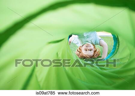 Young boy, upside-down, looking through play tube in garden View Large Photo Image Stock Photography - Young boy, upside-down, looking through play tube in garden. Fotosearch