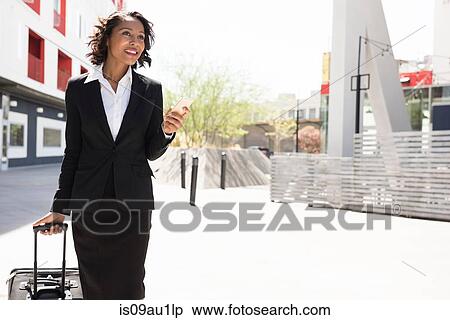 Young businesswoman, pulling suitcase, outdoors View Large Photo Image Stock Photography - Young businesswoman, pulling suitcase, outdoors. Fotosearch