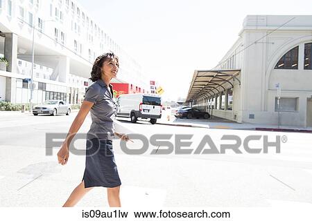 Stock Photo - Young businesswoman, walking, outdoors. Fotosearch