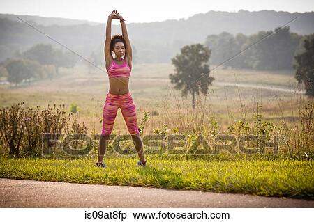 Young female runner warming up on rural park path View Large Photo Image Stock Photography - Young female runner warming up on rural park path. Fotosearch