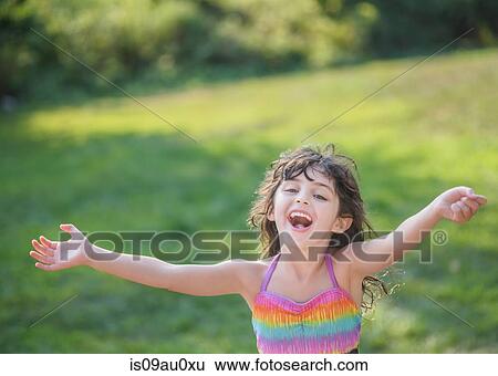 Young girl, arms open, smiling, outdoors View Large Photo Image Stock Photograph - Young girl, arms open, smiling, outdoors. Fotosearch