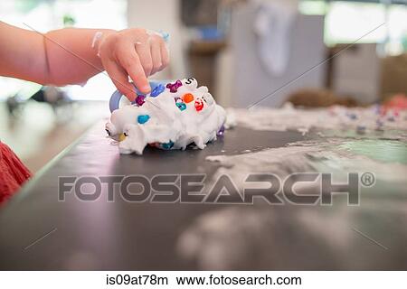 Picture - Young girl playing messy play at table. Fotosearch