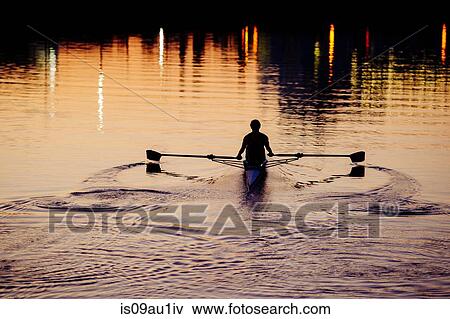 Young man rowing on river at sunset View Large Photo Image Stock Photo - Young man rowing on river at sunset. Fotosearch