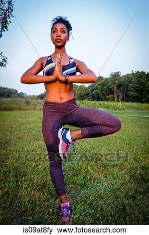 Young woman doing a yoga tree pose in rural park View Large Photo Image Stock Photo - Young woman doing a yoga tree pose in rural park. Fotosearch