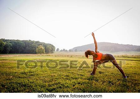 Young woman practicing yoga in rural park View Large Photo Image Stock Photo - Young woman practicing yoga in rural park. Fotosearch