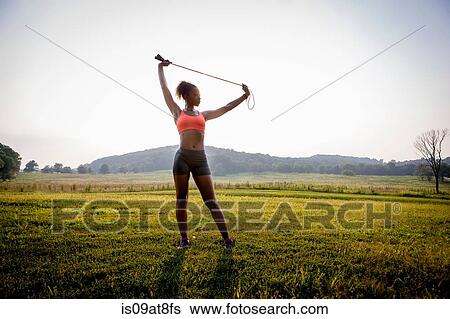 Young woman stretching with skipping rope in rural park View Large Photo Image Stock Photograph - Young woman stretching with skipping rope in rural park. Fotosearch
