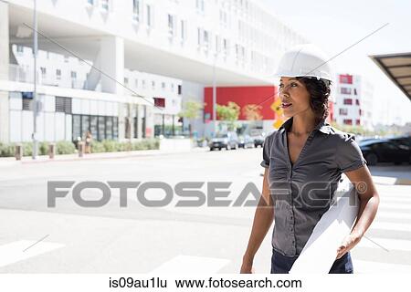 Young woman, wearing hard hat, carrying plans View Large Photo Image Stock Photograph - Young woman, wearing hard hat, carrying plans. Fotosearch