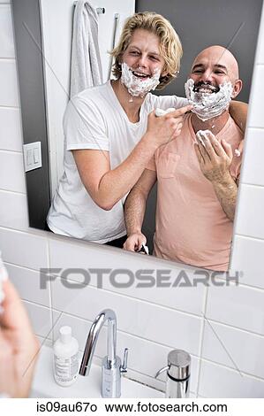 Bathroom mirror image of male couple having fun shaving View Large Photo Image Picture - Bathroom mirror image of male couple having fun shaving. Fotosearch