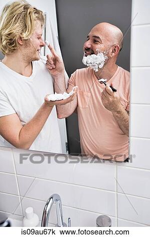Bathroom mirror image of male couple fooling around whilst shaving View Large Photo Image Stock Image - Bathroom mirror image of male couple fooling around whilst shaving. Fotosearch