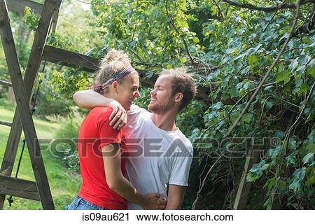 Couple in garden face to face hugging and smiling View Large Photo Image Stock Image - Couple in garden face to face hugging and smiling. Fotosearch