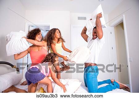 Family pillow fighting on bed, smiling View Large Photo Image Stock Image - Family pillow fighting on bed, smiling. Fotosearch