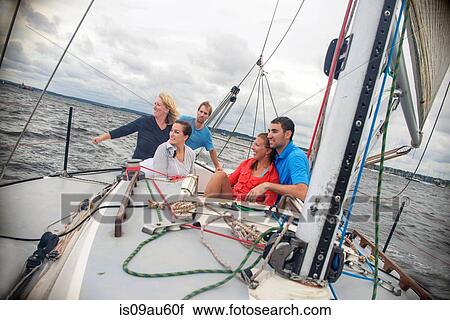 Family relaxing on sailboat, looking away smiling View Large Photo Image Stock Image - Family relaxing on sailboat, looking away smiling. Fotosearch
