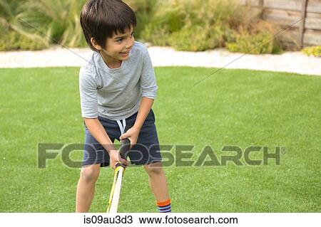 Front view of boy in garden playing cricket looking away smiling View Large Photo Image Stock Image - Front view of boy in garden playing cricket looking away smiling. Fotosearch