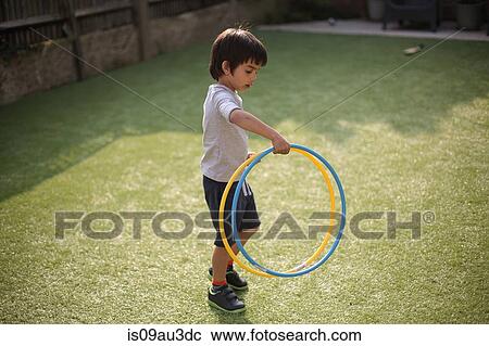 Full length high angle view of boy in garden playing with hula hoops looking down View Large Photo Image Stock Image - Full length high angle view of boy in garden playing with hula hoops looking down. Fotosearch