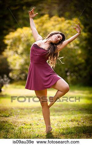 Full length rear view of mid adult woman wearing short dress dancing on grass, on one leg, arms raised View Large Photo Image Stock Image - Full length rear view of mid adult woman wearing short dress dancing on grass, on one leg, arms raised. Fotosearch