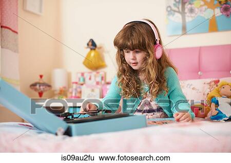 Girl in bedroom wearing headphones and playing vinyl records View Large Photo Image Stock Photograph - Girl in bedroom wearing headphones and playing vinyl records. Fotosearch
