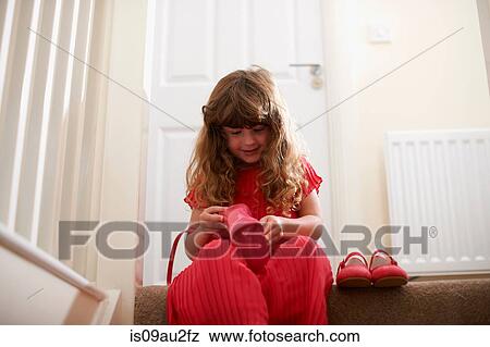 Stock Photo - Girl wearing red on stairway playing with handbag. Fotosearch