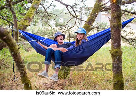 Happy adult couple reclining in blue hammock between trees View Large Photo Image Stock Photography - Happy adult couple reclining in blue hammock between trees. Fotosearch
