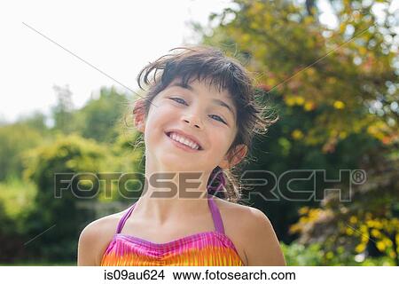 Low angle portrait of girl wearing colourful halter top looking at camera smiling View Large Photo Image Picture - Low angle portrait of girl wearing colourful halter top looking at camera smiling. Fotosearch