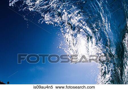 Low angle view of blue ocean wave rolling and splashing overhead View Large Photo Image Stock Photography - Low angle view of blue ocean wave rolling and splashing overhead. Fotosearch