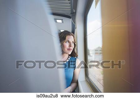 Mid adult woman on train, looking out of window View Large Photo Image Stock Photo - Mid adult woman on train, looking out of window. Fotosearch