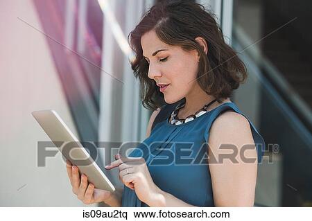 Mid adult woman outdoors, using digital tablet View Large Photo Image Stock Photography - Mid adult woman outdoors, using digital tablet. Fotosearch