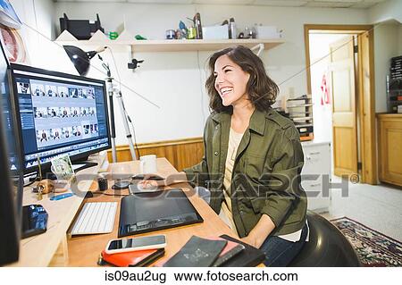Mid adult woman sitting at desk, using graphics tablet, looking at computer screen View Large Photo Image Stock Image - Mid adult woman sitting at desk, using graphics tablet, looking at computer screen. Fotosearch