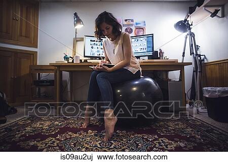 Mid Adult Woman Sitting On Yoga Ball Writing In Diary Stock Image