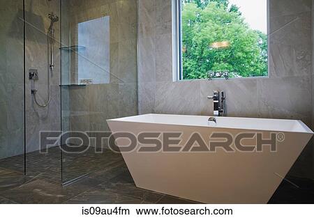 Picture - Modern bathroom with free standing bath tub and glass fronted shower cubicle. Fotosearch