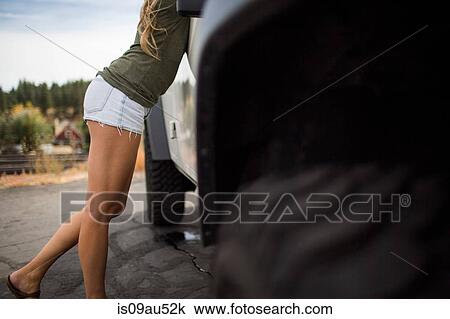 Neck down view of young woman in shorts leaning forward on jeep View Large Photo Image Stock Image - Neck down view of young woman in shorts leaning forward on jeep. Fotosearch