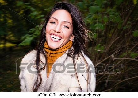 Portrait of mid adult woman wearing fur coat looking at camera smiling View Large Photo Image Stock Image - Portrait of mid adult woman wearing fur coat looking at camera smiling. Fotosearch
