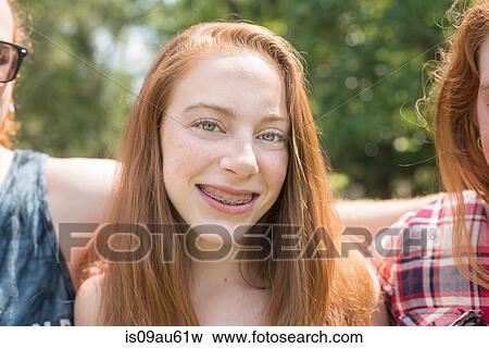 Portrait of red haired young woman with dental braces looking at camera smiling View Large Photo Image Stock Photo - Portrait of red haired young woman with dental braces looking at camera smiling. Fotosearch