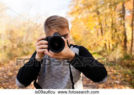Portrait of teenage boy photographing in autumn forest View Large Photo Image Stock Photograph - Portrait of teenage boy photographing in autumn forest. Fotosearch