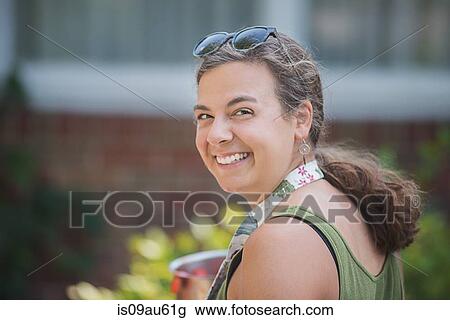 Portrait of woman looking over shoulder at camera smiling View Large Photo Image Stock Image - Portrait of woman looking over shoulder at camera smiling. Fotosearch