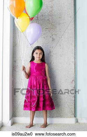 Portrait of young girl holding balloons View Large Photo Image Stock Image - Portrait of young girl holding balloons. Fotosearch