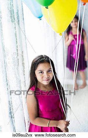 Stock Photo - Portrait of young girl holding balloons. Fotosearch