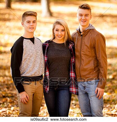 Stock Image - Portrait of young woman and two teenage brothers in autumn forest. Fotosearch