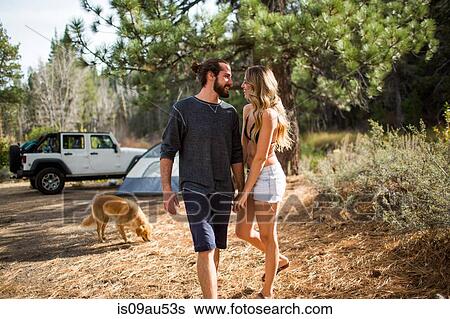 Stock Photograph - Romantic young couple holding hands in forest campsite, Lake Tahoe, Nevada, USA. Fotosearch