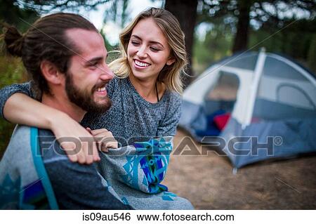 Stock Photograph - Romantic young couple wrapped in blanket on campsite, Lake Tahoe, Nevada, USA. Fotosearch