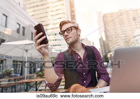 Stressed young businessman reading smartphone at sidewalk cafe, New York, USA View Large Photo Image Stock Image - Stressed young businessman reading smartphone at sidewalk cafe, New York, USA. Fotosearch