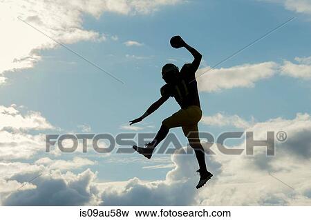 Teenage american football player, jumping with ball, mid air View Large Photo Image Stock Photo - Teenage american football player, jumping with ball, mid air. Fotosearch