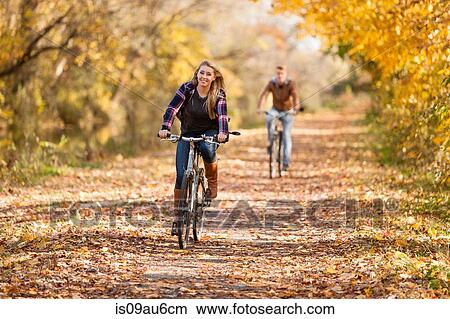 Teenage boy and adult sister cycling in autumn forest View Large Photo Image Picture - Teenage boy and adult sister cycling in autumn forest. Fotosearch