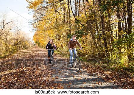 Teenage boy and adult sister cycling along autumn forest road View Large Photo Image Stock Image - Teenage boy and adult sister cycling along autumn forest road. Fotosearch