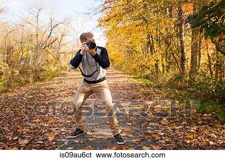 Teenage boy photographing from road autumn park forest View Large Photo Image Stock Photograph - Teenage boy photographing from road autumn park forest. Fotosearch