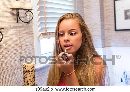 Stock Photography - Teenager putting on make-up in bathroom. Fotosearch