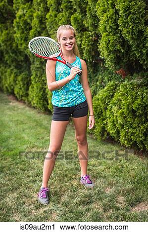 Teenager with tennis racket in garden View Large Photo Image Stock Image - Teenager with tennis racket in garden. Fotosearch