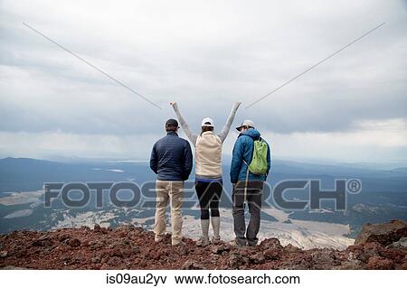 Stock Photo - Three friends standing at the summit of South Sister volcano, looking at view, Bend, Oregon, USA. Fotosearch