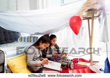 Two young girls, sitting inside home-made tent, playing View Large Photo Image Stock Photograph - Two young girls, sitting inside home-made tent, playing. Fotosearch