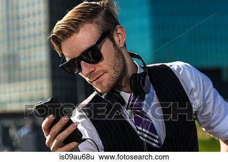 Young businessman in front of office reading smartphone texts, New York, USA View Large Photo Image Stock Photograph - Young businessman in front of office reading smartphone texts, New York, USA. Fotosearch